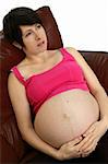 A pregnant young woman sitting on a couch