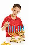 Young boy lighting the menorah for Hanukkah.  Isolated on white.