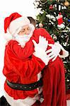 Santa Claus getting a big hug from a child on Christmas morning.  White background.