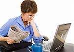 Businesswoman checks the financial markets in the newspaper and online.  White background.