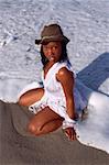 African-American woman in hat posing in seawaters