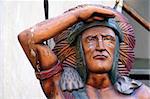 A Wooden Indian looking with hand over eyes