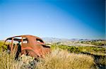 An old, long abandoned vehicle, rusting away in a very rugged, harsh environment.