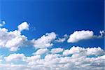 Background of deep blue sky with white fluffy clouds at the bottom