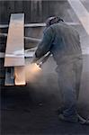 worker sandblasting steel