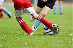 Detail of a football match - focus on the feet and the football