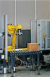 Robotic arm at work in factory packing boxes