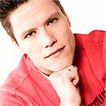 Portrait of a young man dressed in a red sweater looking thoughtful