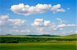 Scenic grassland in summer with clouds in the sky.