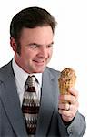 A handsome businessman looking excitedly at a chocolate ice cream cone.