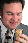 A closeup of a businessman looking at an ice cream cone with love.