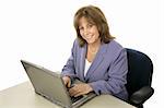 A friendly, attractive female executive working on her laptop and smiling at the camera.  Isolated on white.