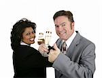 An attractive couple in suits toasting with champagne.  They could be dating or celebrating a business partnership.