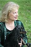 A portrait of a mature woman and her dachshund in profile.