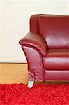 Part of dark red leather sofa with armrest