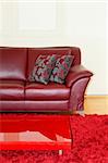 Part of dark red leather sofa and pillows