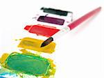 set of multi-colored watercolor paint with brush on white background