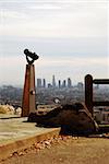Telescope facing and pointing to downtown Los Angeles, California from a vista.