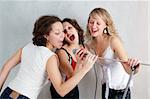 three beautiful expressive singing women with microphone