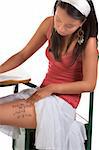 Female student taking exam cheating using notes on her thigh