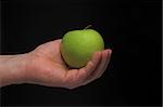 A person holding a Granny Smith apple.