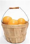 Delicious oranges in a wooden bushel basket.