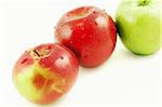 Three apples lined up in a row isolated on a white background. Rome, Red Delicious, Granny Smith