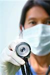 Close-up of nurse with stethoscope on pale background