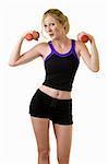 Attractive blond woman in black shorts and workout top doing arm exercises with two red three pound weights on white