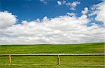 Beautiful meadow with a great blue sky and wooden fence