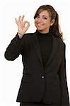 Attractive brunette woman in professional business suit standing on white smiling making the okay sign with her hand