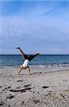 Boy doing acrobatics on the beach