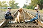 Boys And Dog Sitting on Train Tracks