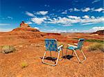Two lawn chairs in scenic desert landscape with  land formation.