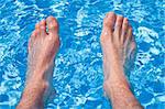 Holliday Relaxation on Pool - Men feet in transparent water