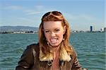 Beautiful redhead in a leather jacket in a boat on San Francisco Bay