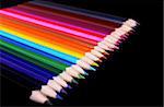 Colorful pencils in a row isolated over black background