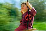 smilling boy on a swing with motion blur