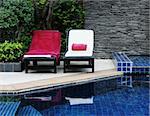 Deck chairs next to a swimming pool.