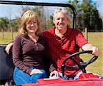 Fit youthful retired couple riding an all terrain vehicle.