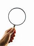 Hand holding a magnifying glass on white background. Including clipping path (Inside and outside of magnifying glass)