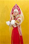 Russian woman in a folk russian dress on yellow background