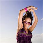 Portrait of young happy woman dancing with sunglasses