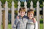 Two Boys in Front of a Fence