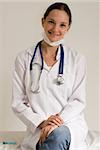 Young female doctor in a white coat with a stethoscope and a big smile. Isolated.