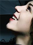 A portrait about a pretty lady with white skin and long brown wavy hair, she is looking up and she is laughing