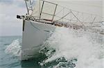 Close up on the bow of a sailing yacht breaking through a wave