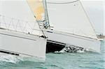Close up on the bows of two racing yachts in close competition