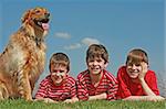 Three Young Boys Laying With the Dog