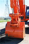 Orange excavator close up on a construction sight.